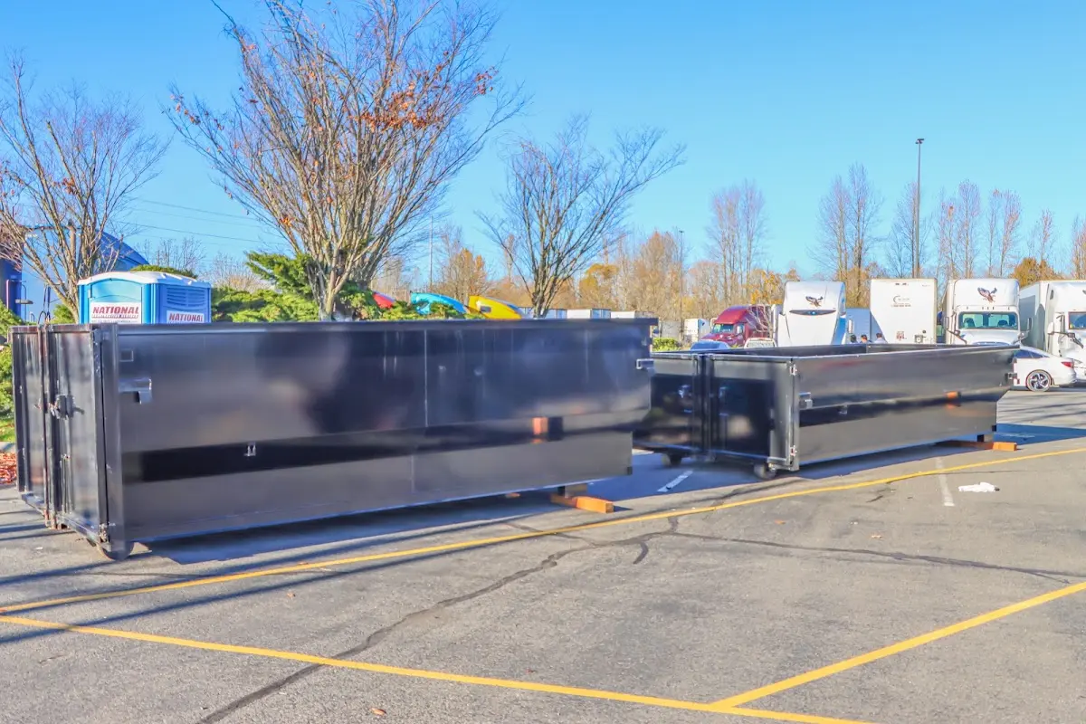 Professional dumpster rental service with roll-off container on residential driveway in Howard